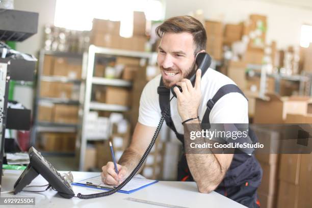 man making a delivery list - landline phone imagens e fotografias de stock