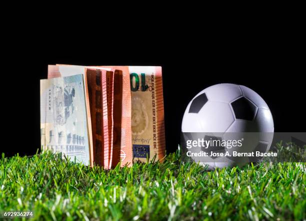 ball of football on the lawn and a heap of tickets of euro, business concept in the football - turnover sport imagens e fotografias de stock