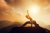 Asian man, fighter practices martial arts in high mountains at sunset.