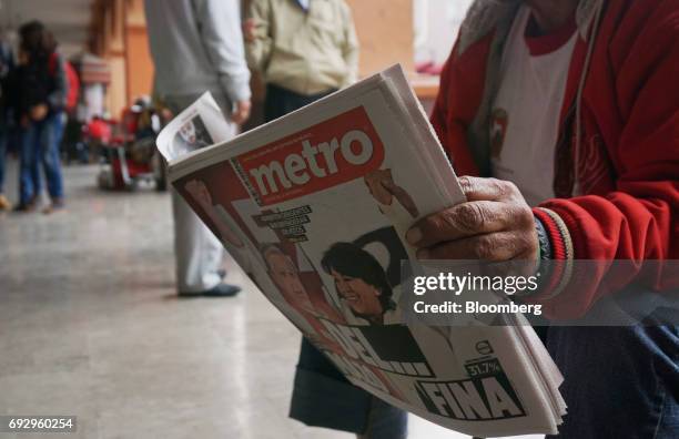 Resident reads the Metro newspaper featuring the cover images of Alfredo del Mazo, Institutional Revolutionary Party candidate for governor of the...