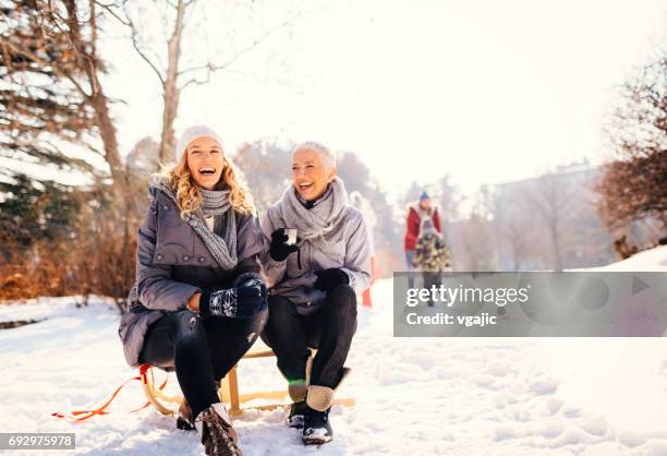 two generation family having fun outdoors at winter - middle aged woman winter stock pictures, royalty-free photos & images