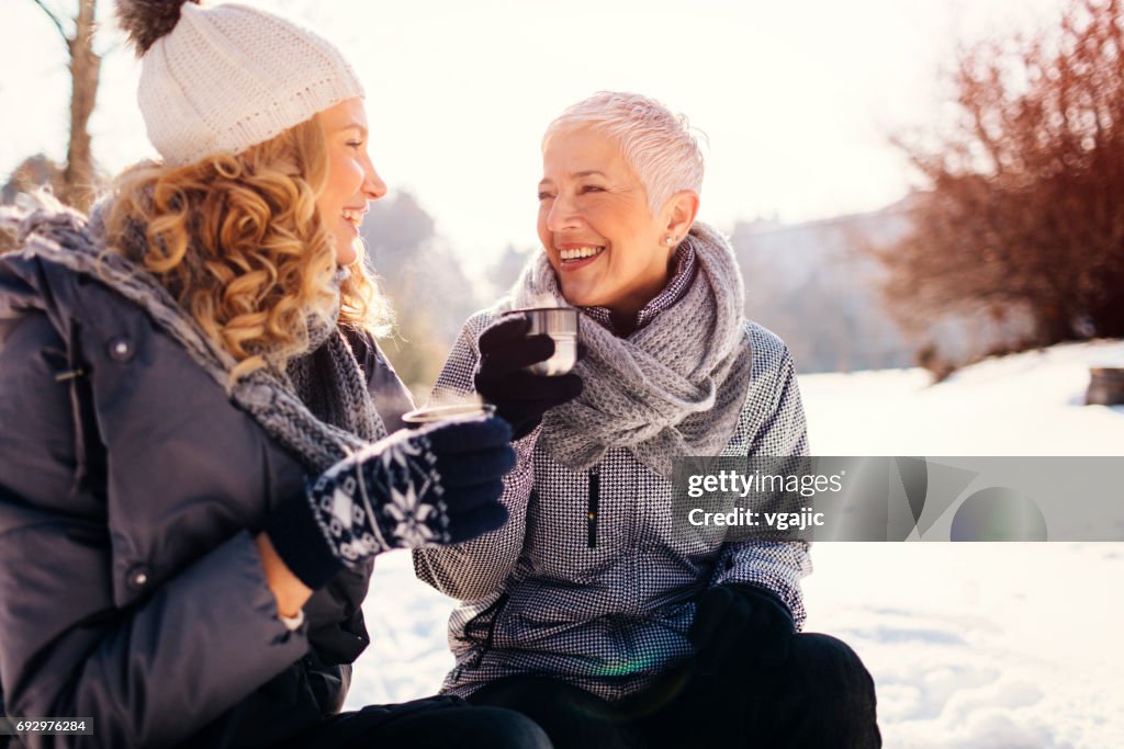 Women Drinking Tea Outdoors At Winter