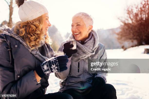 women drinking tea outdoors at winter - middle aged woman winter stock pictures, royalty-free photos & images