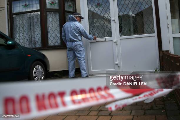 Police officer forensic officer enters a house during a police operation at a residence in Ilford, in east London on June 6 in the wake of an attack...