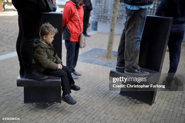 Young boy sits it out as people stand on benches to see Labour Leader Jeremy Corbyn deliver a speech during a rally at Southwater Library on June 6,...