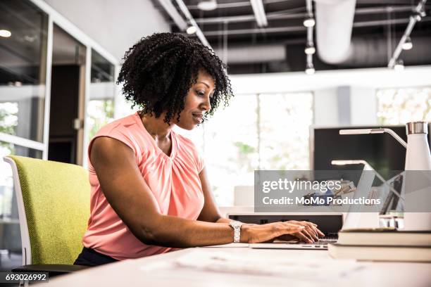 woman working in modern business office - mid length hair stock pictures, royalty-free photos & images