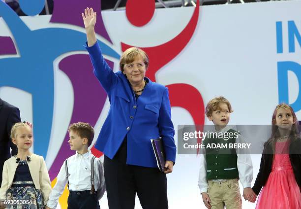 German Chancellor Angela Merkel stands with children during the Stadium Gala of the 2017 Deutsches Turnfest at the Olympic Stadium in Berlin on June...