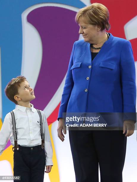 German Chancellor Angela Merkel and a young boy look at each other during the Stadium Gala of the 2017 Deutsches Turnfest at the Olympic Stadium in...