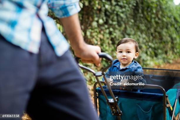 niño en carro de juguete mirando a cámara - vagón fotografías e imágenes de stock