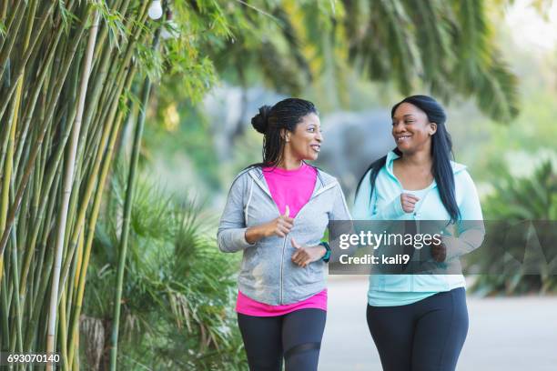 zwei afroamerikanische frauen gemeinsam joggen - power walking stock-fotos und bilder