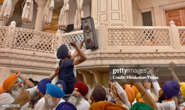 Sikh radical activists damaging the speaker installed outside the Akal Takht building during a protest against Jathedar Gaini Gurbachan Singh in the...