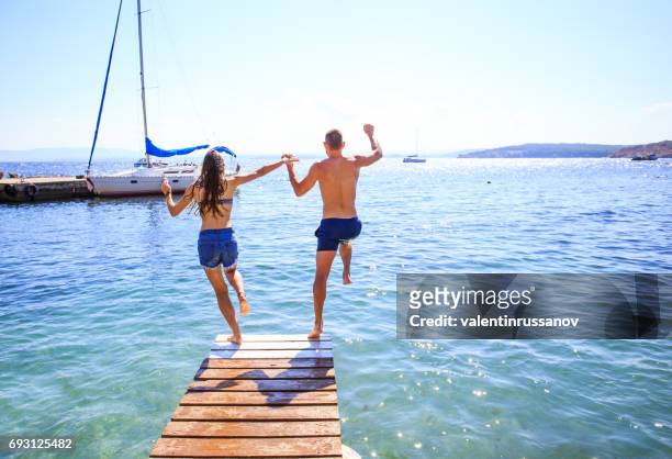 coppia che salta in acqua - bulgaria foto e immagini stock