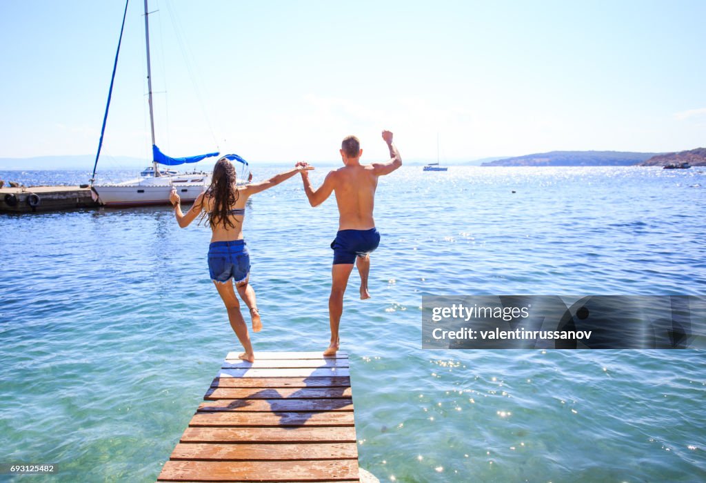 Couple jumping into water