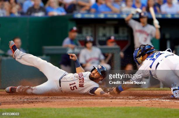 Carlos Beltran of the Houston Astros slides safely into home plate to score avoiding the tag of Salvador Perez of the Kansas City Royals during the...