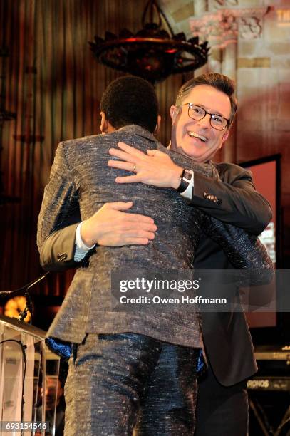 Musician Jon Batiste and comedian Stephen Colbert embrace onstage during the Gordon Parks Foundation Awards Dinner & Auction at Cipriani 42nd Street...