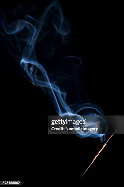 smoking incense stick flash illuminated close-up - wispy stock pictures, royalty-free photos & images
