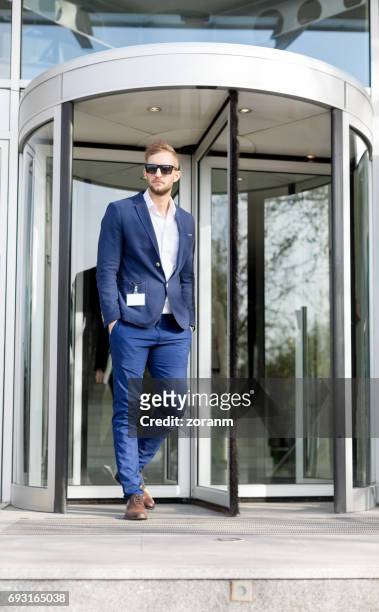 businessman in front of office building - revolve stock pictures, royalty-free photos & images