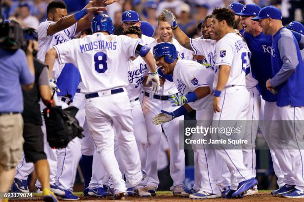 Mike Moustakas of the Kansas City Royals is congratulated by teammates after hitting a walk-off game-winning home run during the 9th inning of the...