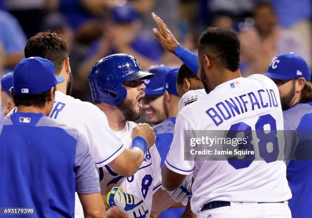 Mike Moustakas of the Kansas City Royals is congratulated by teammates at home plate after hitting a walk-off game-winning home run during the 9th...