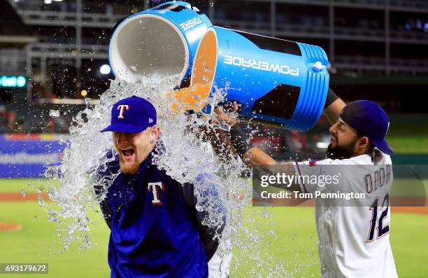 Rougned Odor of the Texas Rangers and Elvis Andrus of the Texas Rangers soak Dillon Gee of the Texas Rangers with Powerade and water after earning...