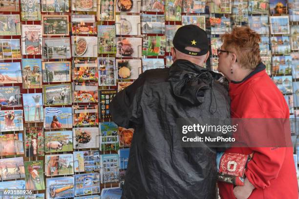 Couple of tourists outside a shop with post-cards and souvenirs in Sainte-Mere-Eglise. Tuesday 6th June is the 73rd anniversary of the D-Day landings...