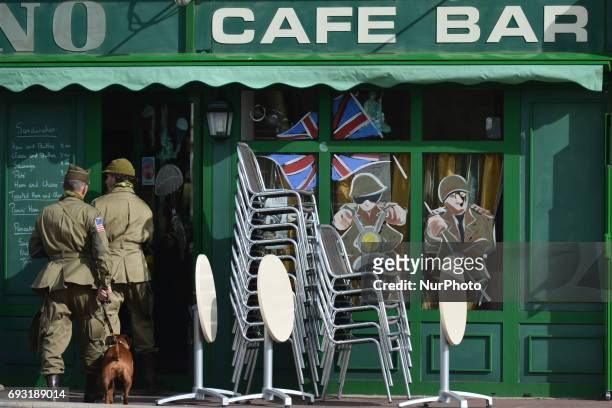People dressed in the US Army D-Day uniforms enter into a local Cafe Bar in Sainte-Mere-Eglise. Tuesday 6th June is the 73rd anniversary of the D-Day...
