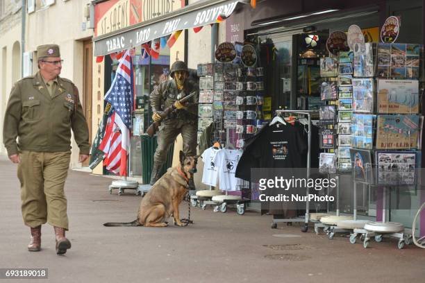 Man dressed in US uniform from D-Day time passes near a a shop with post-cards and souvenirs in Sainte-Mere-Eglise. Tuesday 6th June is the 73rd...