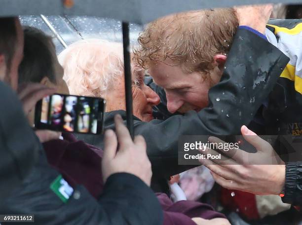 Prince Harry hugs 97-year-old Daphne Dunne, who he had met on an earlier visit to Sydney, during an event where he met members of the public in the...