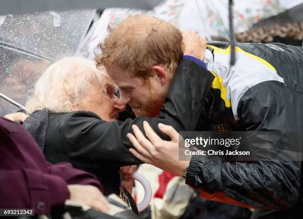 Patron of the Invictus Games Foundation Prince Harry hugs 97 year old Daphne Dunne during a walkabout in the torrential rain ahead of a Sydney 2018...