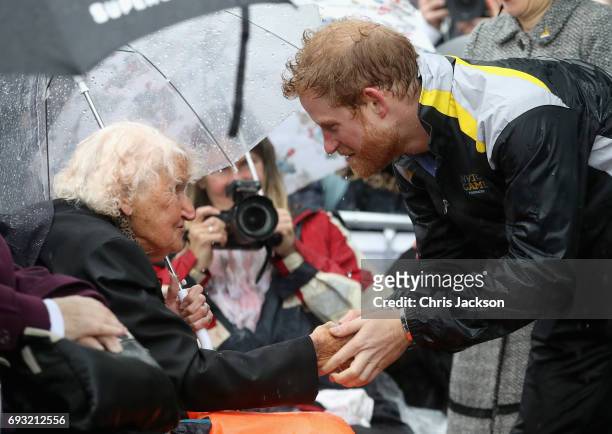 Patron of the Invictus Games Foundation Prince Harry hugs 97 year old Daphne Dunne during a walkabout in the torrential rain ahead of a Sydney 2018...