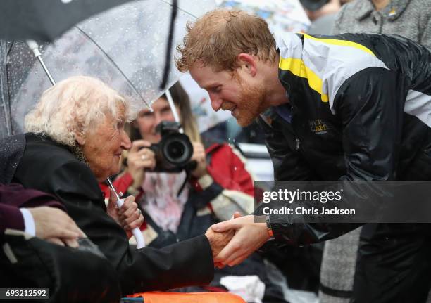 Patron of the Invictus Games Foundation Prince Harry hugs 97 year old Daphne Dunne during a walkabout in the torrential rain ahead of a Sydney 2018...