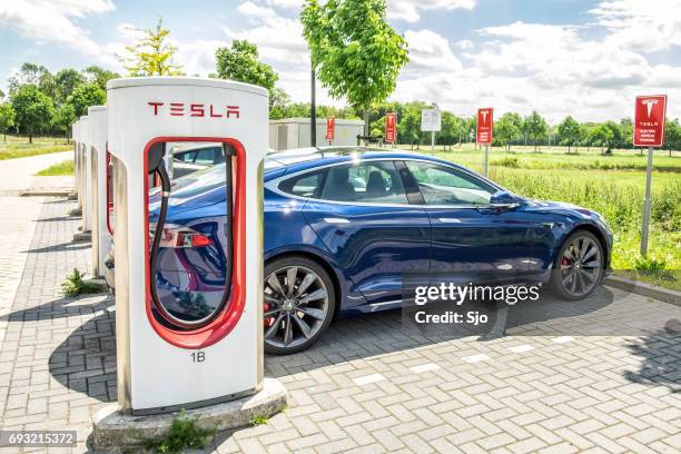 tesla model s electric car at a supercharger charging station - tesla model s stock pictures, royalty-free photos & images