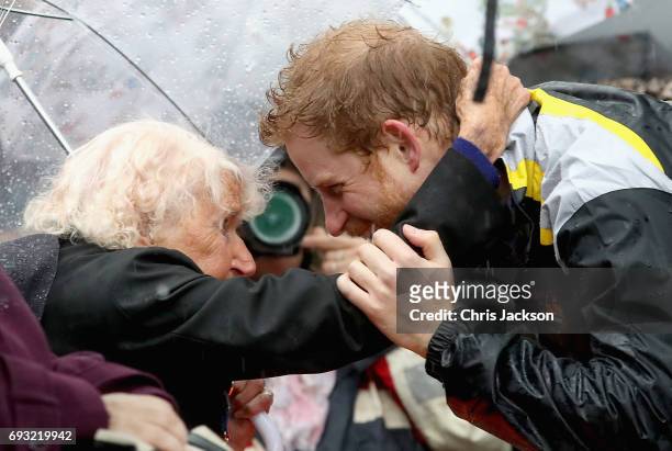 Patron of the Invictus Games Foundation Prince Harry hugs 97 year old Daphne Dunne during a walkabout in the torrential rain ahead of a Sydney 2018...