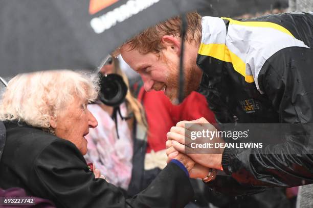 Britain's Prince Harry meets with Daphne Dunne at The Rocks in Sydney on June 7, 2017. Prince Harry on June 7 paid tribute to victims of the London...