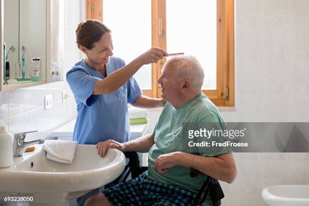 casa cuidador con hombre mayor en cuarto de baño - asistencia de la comunidad fotografías e imágenes de stock