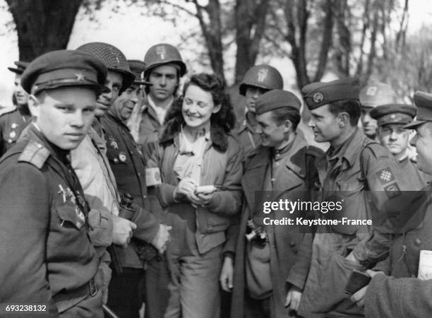 La correspondante de guerre Ann Stringer est entourée de soldats des armées russes et américaines qui viennent de se rejoindre , à Torgau, Allemagne,...