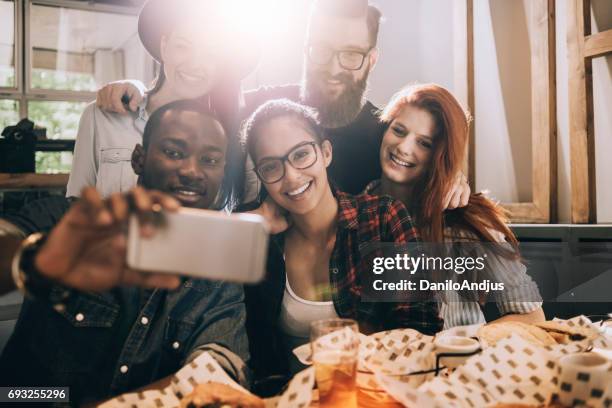 groep vrienden nemen van een selfie in een bar - sun flare on glass stockfoto's en -beelden