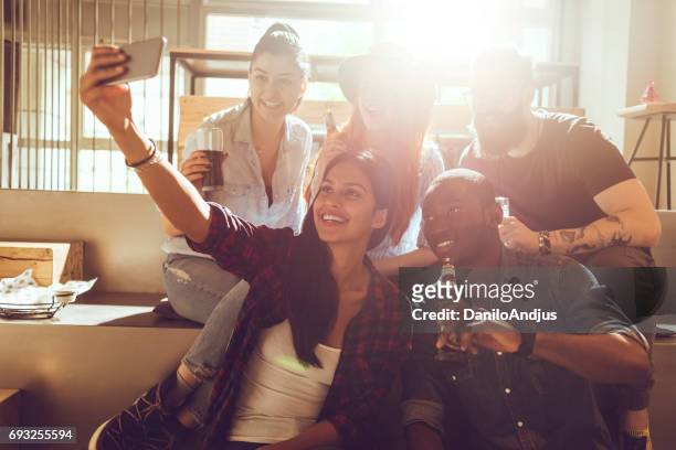 groep vrienden nemen van een selfie in een bar - sun flare on glass stockfoto's en -beelden