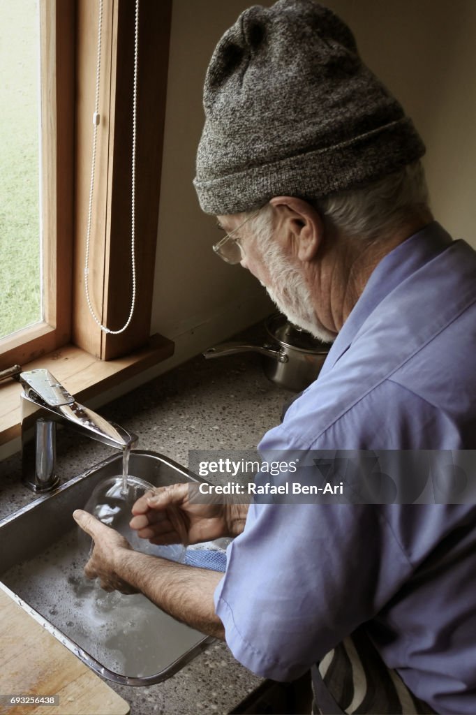 Senior man washing up dishes