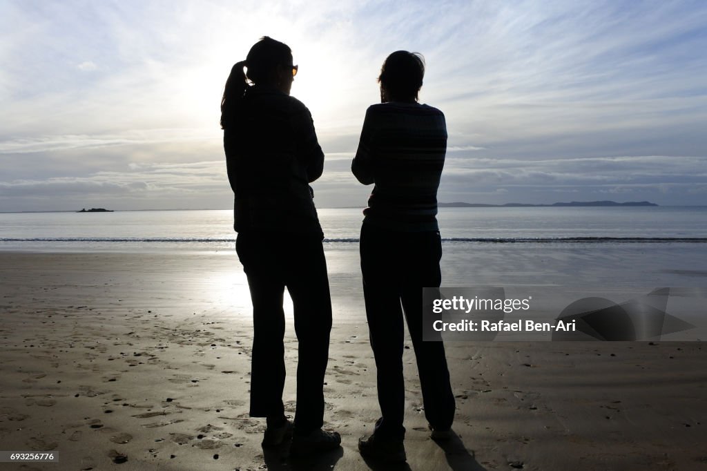 Mother and daugther talking on a beach