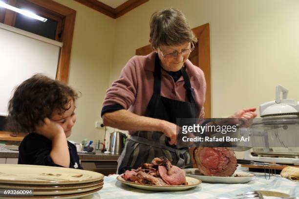 grandmother and granddaughters cooking togather - roast lamb stock pictures, royalty-free photos & images
