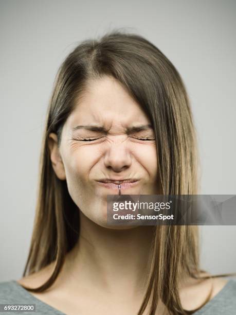 real young woman with pain expression - portrait grimace stock pictures, royalty-free photos & images