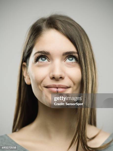 real happy young woman studio portrait looking up - mouth smirk stock pictures, royalty-free photos & images