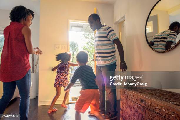 candid shot of african american family in hallway - leaving stock pictures, royalty-free photos & images