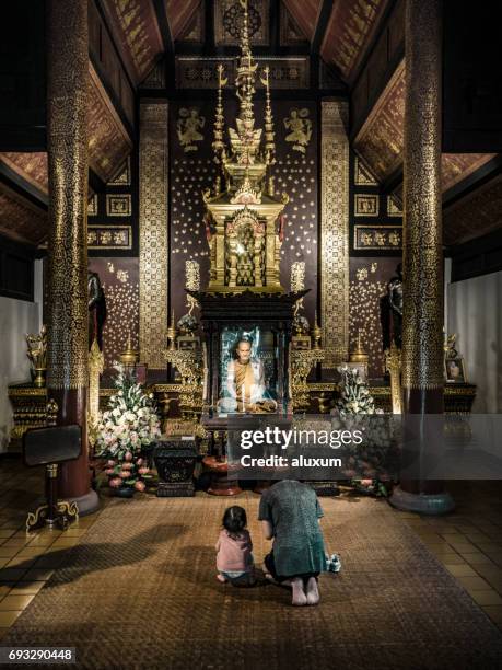 woman and child praying in buddhist temple thailand - cidade de chiang mai imagens e fotografias de stock