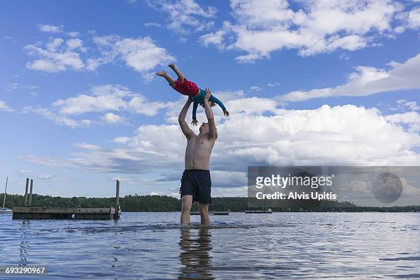 father plays with son in maine lake. - lake auburn photos et images de collection