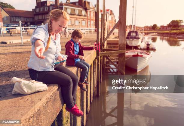 mother and young son fishing for crabs - blakeney stock pictures, royalty-free photos & images