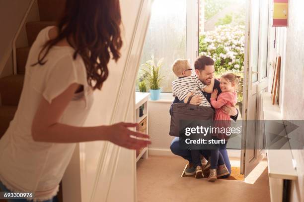 daddy's homecoming hug - family smiling at front door stock pictures, royalty-free photos & images