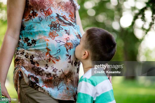 gentle preschooler kissing new baby to come - belly kissing stock pictures, royalty-free photos & images