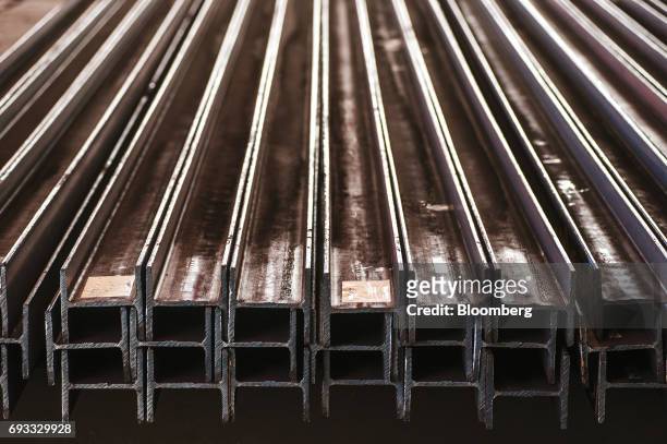 Steel beams for structural construction use sit stacked in the storage area inside the ArcelorMittal HighVeld Steel & Vanadium Corp. Plant in...